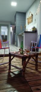 uma mesa com dois copos e uma garrafa em Casa aconchego da Camila em Foz do Iguaçu