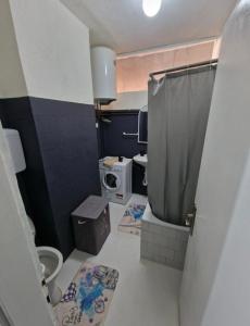 a small bathroom with a toilet and a microwave at Black & White Modern Apartment in Tuzla