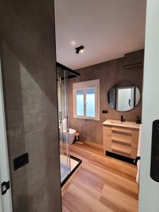 um banheiro com chuveiro, pia e espelho em Caímachado em Cádis