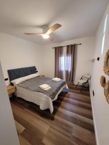 um quarto com uma cama e uma ventoinha de tecto em Caímachado em Cádiz