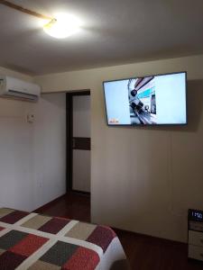 a bedroom with a flat screen tv on the wall at Casa com Piscina in Serra