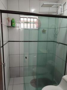 La salle de bains est pourvue d'une douche en verre et de toilettes. dans l'établissement Casa com Piscina, à Serra