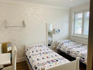 a bedroom with two beds and a mirror at Botany Bay view Seaside Home in Broadstairs