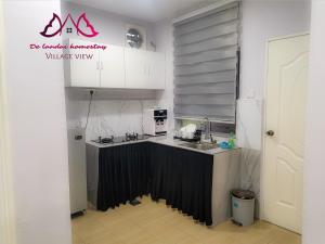 a kitchen with a black and white counter top at D landai homestay in Pekan