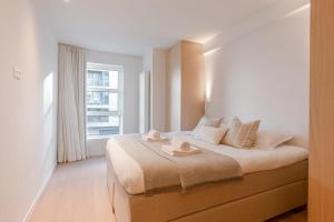 1 dormitorio con 1 cama grande y ventana en Luxury apartment with parking in Knokke en Knokke-Heist