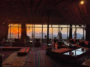 uma grande sala com sofás e mesas e um pôr-do-sol em Rocky Mountains Hotel em Wadi Musa