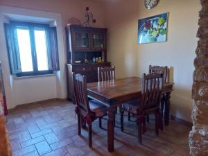 ein Esszimmer mit einem Holztisch und Stühlen in der Unterkunft Casa Marzocco in Pomarance