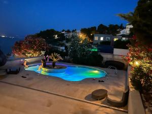 una piscina en un patio trasero por la noche en Hotel Marco Polo en Slatine