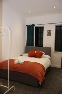 um quarto com uma cama com almofadas laranja e branca em Modern home in Birmingham em Birmingham
