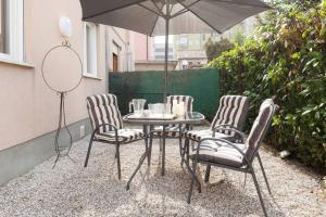 - une table et des chaises avec un parasol sur la terrasse dans l'établissement Vintage Apartment Venetian Mood, à Mestre