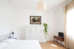 - une chambre blanche avec un lit blanc et une télévision dans l'établissement Vintage Apartment Venetian Mood, à Mestre