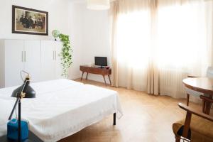 - une chambre blanche avec un lit et une table dans l'établissement Vintage Apartment Venetian Mood, à Mestre