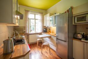 eine Küche mit einem Kühlschrank aus Edelstahl und einem Tisch in der Unterkunft Hübsches Privatzimmer mit Bad in Perchtoldsdorf