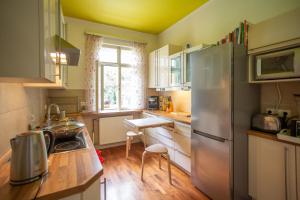 a kitchen with a stainless steel refrigerator and a table at Hübsches Privatzimmer mit Bad in Perchtoldsdorf