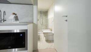 Un baño con inodoro, lavabo y puerta. en Italianway - The B Village Standard, en Milán 141 fotos más