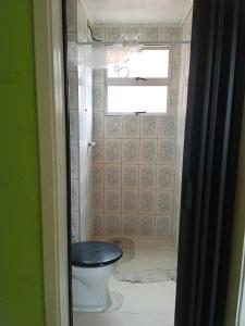 ein Bad mit einem WC und einem Fenster in der Unterkunft Apartamento para temporada in Mongaguá