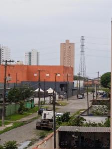 eine Stadtstraße mit einem großen Backsteingebäude im Hintergrund in der Unterkunft Apartamento para temporada in Mongaguá