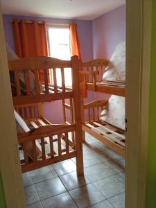 Zimmer mit 2 Etagenbetten und einem Fenster in der Unterkunft Apartamento para temporada in Mongaguá