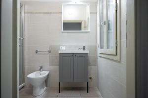 Baño blanco con lavabo y aseo en Duomo Apartment, en Florencia