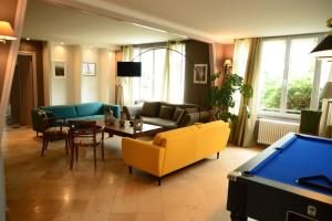 a living room with couches and a pool table at Vaste Maison de 300 m2 en forme de bateau pour 15 L'Iliade in Port-en-Bessin-Huppain