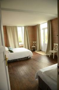 a bedroom with two beds and two windows at Vaste Maison de 300 m2 en forme de bateau pour 15 L'Iliade in Port-en-Bessin-Huppain