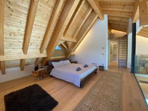 ein Schlafzimmer mit einem großen Bett und Holzdecken in der Unterkunft Luxury Chalet in the Tarvisio mountains in Camporosso in Valcanale