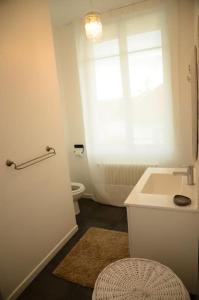 a bathroom with a sink and a toilet and a window at Vaste Maison de 300 m2 en forme de bateau pour 15 L'Iliade in Port-en-Bessin-Huppain