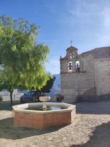 una fuente frente a un edificio con iglesia en Hotel Rural Aznaitín, en Albanchez de Úbeda