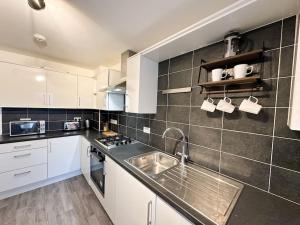a kitchen with a sink and a counter top at Densham House by Blue Skies Stays in Stockton-on-Tees