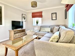 a living room with a couch and a tv at Fewster Apartment - City Centre location with free parking in York