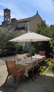 a table with an umbrella in front of a building at Mas d'Alaure B&B in Verquières