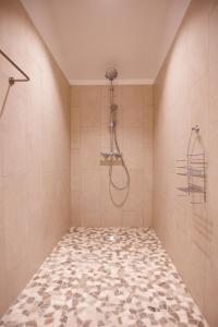 een badkamer met een douche en een tegelvloer bij Mas d'Alaure B&B in Verquières
