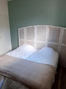 1 dormitorio con cama blanca y persianas en Appart magnifique avec une vue exceptionnelle OLERON, en La Bernerie-en-Retz