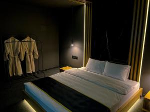a bedroom with a bed in a room with clothes racks at Atlas Hotel in Almaty