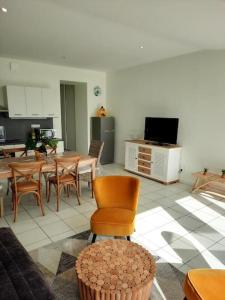 a living room with a table and chairs and a kitchen at Appart magnifique avec une vue exceptionnelle OLERON in La Bernerie-en-Retz +6 photos