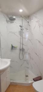 a white bathroom with a shower and a sink at Los Cristianos Tenerife in Los Cristianos