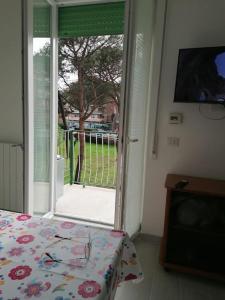 a room with a bed and a sliding glass door at Monolocale Ostia locaz.turistica in Lido di Ostia