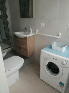 uma casa de banho com um WC e uma máquina de lavar roupa em Monolocale Ostia locaz.turistica em Lido di Ostia