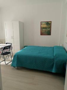 1 dormitorio con 1 cama con manta verde en Monolocale Ostia locaz.turistica, en Lido di Ostia