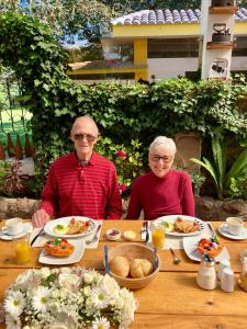 an older man and woman sitting at a table with food at Hosteria Casa Silva in Checa