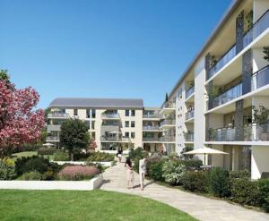 two people walking down a sidewalk in front of a building at ESCAL'HOME , appart design au pied de l'aéroport,parkings in Blagnac