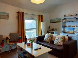 uma sala de estar com um sofá e uma mesa em Salt Marsh Apartment em Tywyn