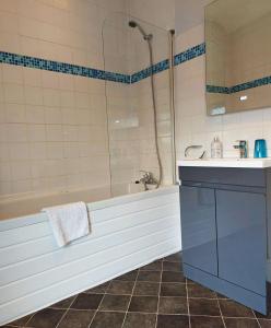 a bathroom with a tub and a sink and a shower at Salt Marsh Apartment in Tywyn