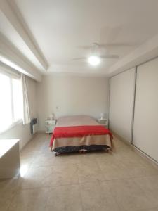 1 dormitorio con 1 cama con manta roja en Apart Boulogne, a metros de los portones del parque San Martin en Mendoza