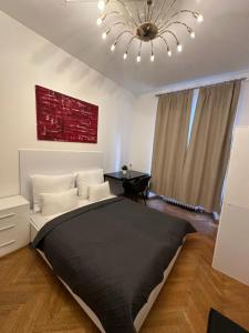 sypialnia z dużym łóżkiem i żyrandolem w obiekcie DATRI Petite Suite 1 - 3 w Wiedniu