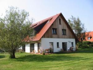 ein großes weißes Haus mit rotem Dach in der Unterkunft Hotel GODEWIND in Hiddensee