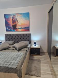 a bedroom with a bed with a painting on the wall at Casa ALEX in Apărătorii Patriei