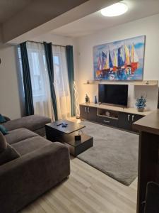 a living room with a couch and a flat screen tv at Casa ALEX in Apărătorii Patriei