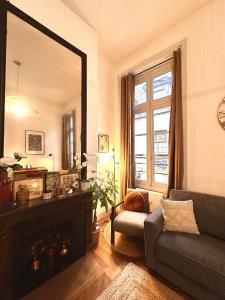 sala de estar con espejo y sofá en Les appartements de l'atelier Paris 3 en París
