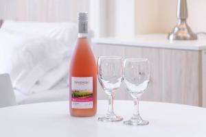 butelkę wina i dwa kieliszki wina na stole w obiekcie Residencial Suiza w mieście Lima